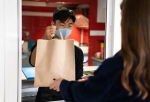 restaurant-worker-handing-order-client